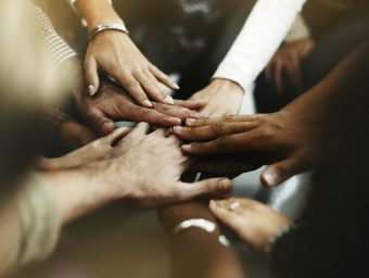 Closeup of diverse people joining their hands