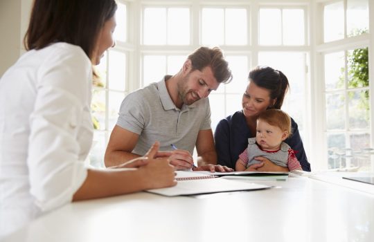 Family With Baby Meeting Financial Advisor At Home