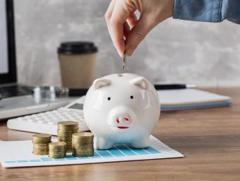 hand-putting-coin-in-piggy-bank-and-growth-chart